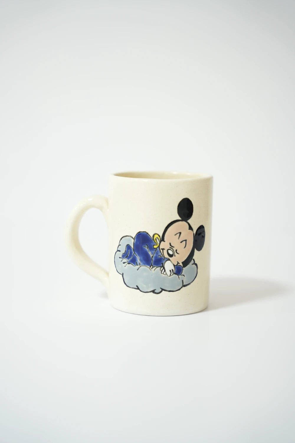 فنجان سيراميك أبيض مع رسمة ميكي نائم على غيمة.