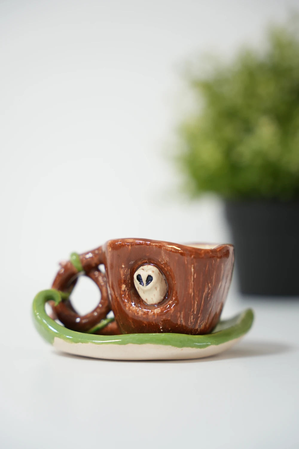 كوب يشبه جذع شجرة مع بومة وقاعدة ورقة شجر